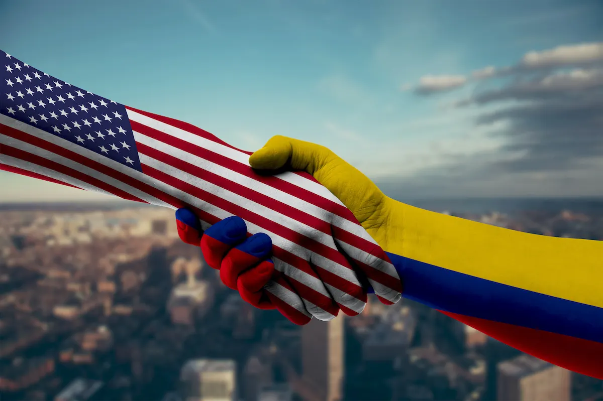 Apretón de manos entre las banderas de Colombia y Estados Unidos